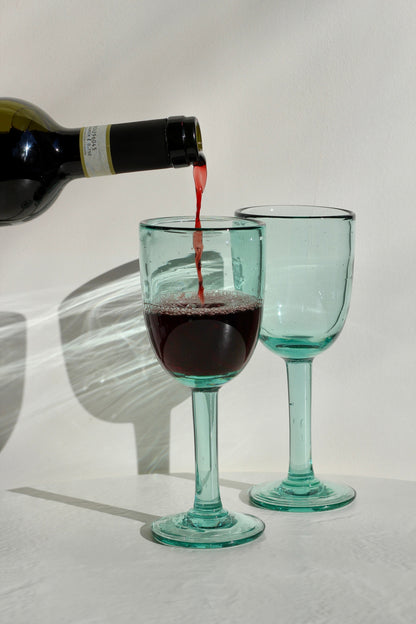 A funky, one-of-a-kind wine glass designed to bring character to any table. With its distinctive handmade feel, this stemmed glass adds a fun touch to serving wine. Each piece is handblown with recycled glass by artisan partners in Bogotá, Colombia.