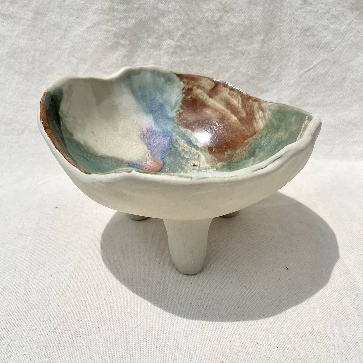 Heavy footed dish made from white clay with a variety of glazes. For your fruit, your jewelry, candles, shared food dish, whatever! Hand built, glazed and fired in San Luis Obispo  by Roaming Barefoot Ceramics.