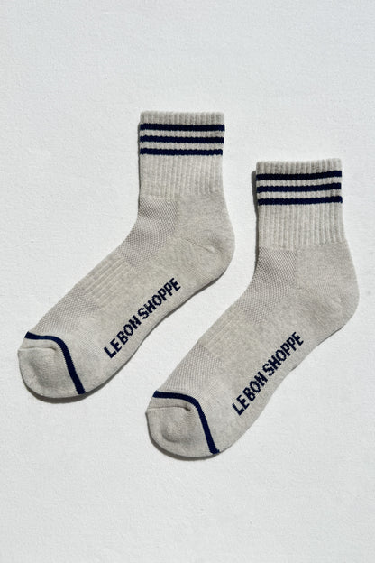 Gray socks with blue stripes and 'Le Bon Shoppe' branding on a white background