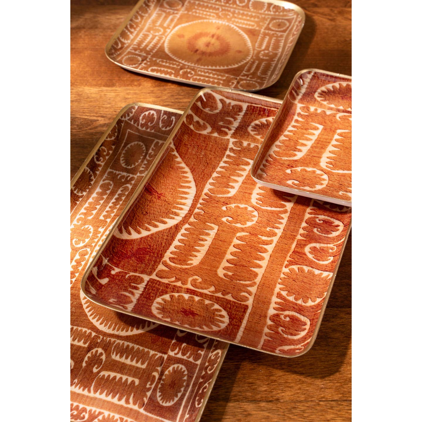 Featuring a bold rusty orange backdrop adorned with vintage-inspired Suzani patterns, these serving trays are ideal for adding both style and utility to your space.