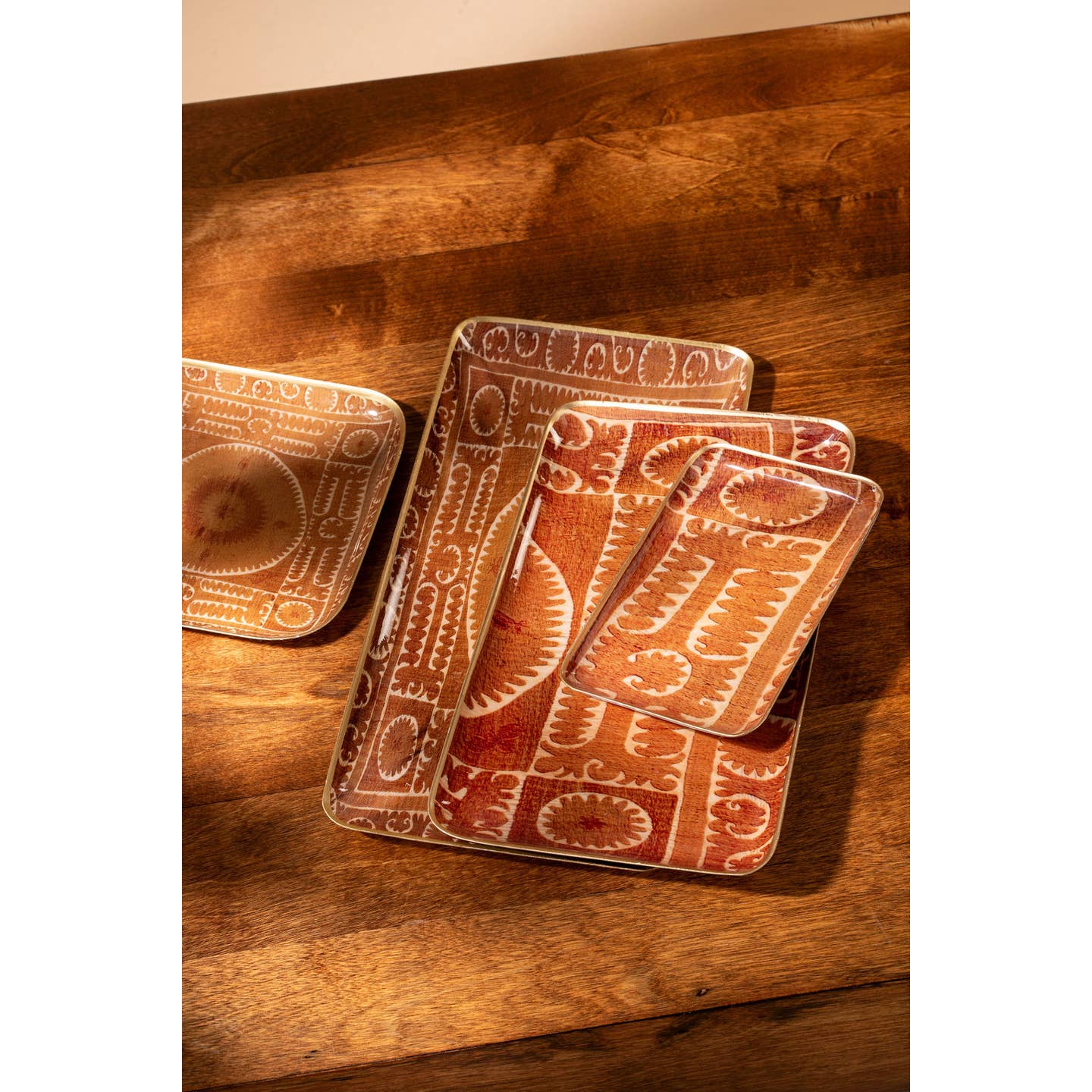 Featuring a bold rusty orange backdrop adorned with vintage-inspired Suzani patterns, these serving trays are ideal for adding both style and utility to your space.