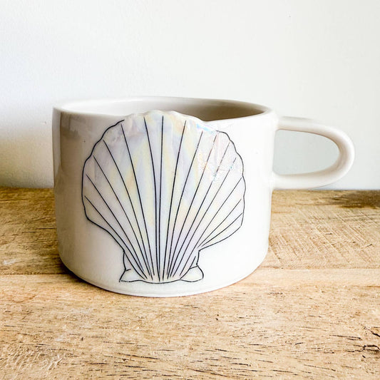 Seashell mugs are hand-thrown from fine porcelain, and feature hand drawn inlay and mother of pearl luster for a delicate and iridescent shine.