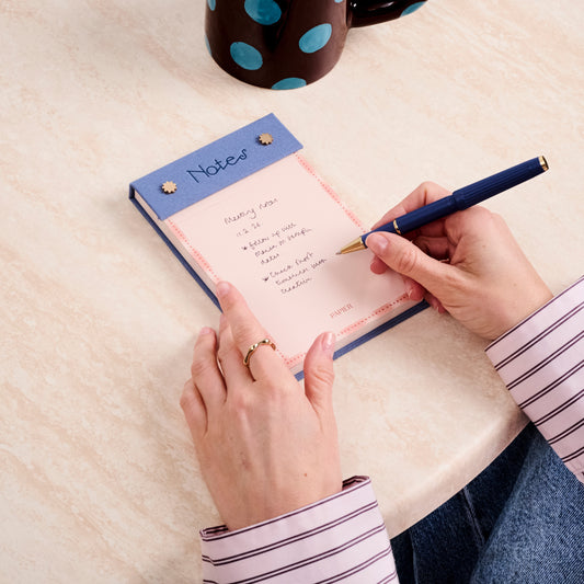 Papier's fabric notepad brings a tactile twist to everyday list-making.

Wrapped in a textured fabric cover, it’s a space to elevate quick notes, reminders, and daily to-dos into something more considered.