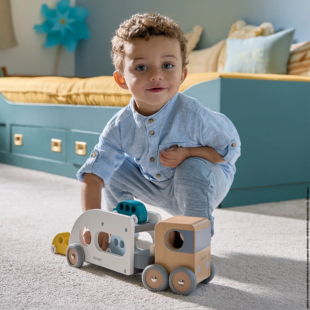 This big wooden car transporter truck, with a detachable trailer, can deliver 3 cars at a time. It will go everywhere thanks to its large steering angle. The transporter has rubber wheels, which are perfectly silent. 3 cars included. Develop your child’s imagination and fine motor skills. Made from solid FSC TM wood and water-based paint.