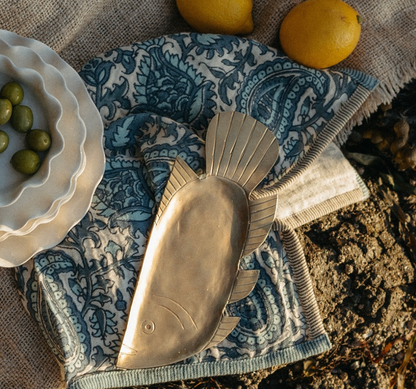 Forged iron fish dish in a coastal table setting.