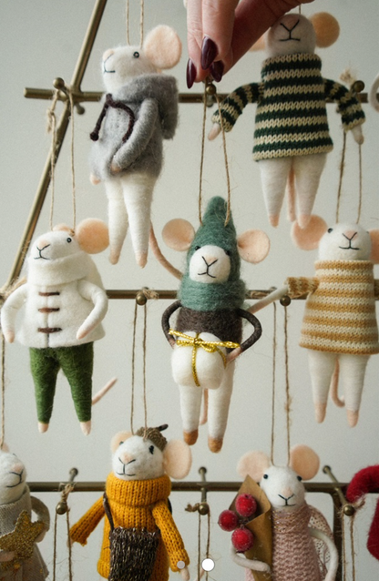 Handmade mouse figurines in various outfits hanging on a wire rack.