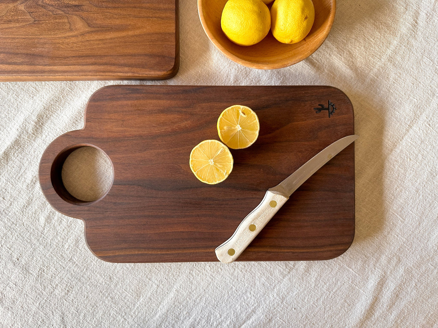 A modern design featuring a circular handle. These are made out of either hard maple that is know for its neutral grain and durable surface or dark walnut that is know for its moody grain with stripes of caramel. Great boards to grab for a quick chop or made as your designated home bar board for citrus.