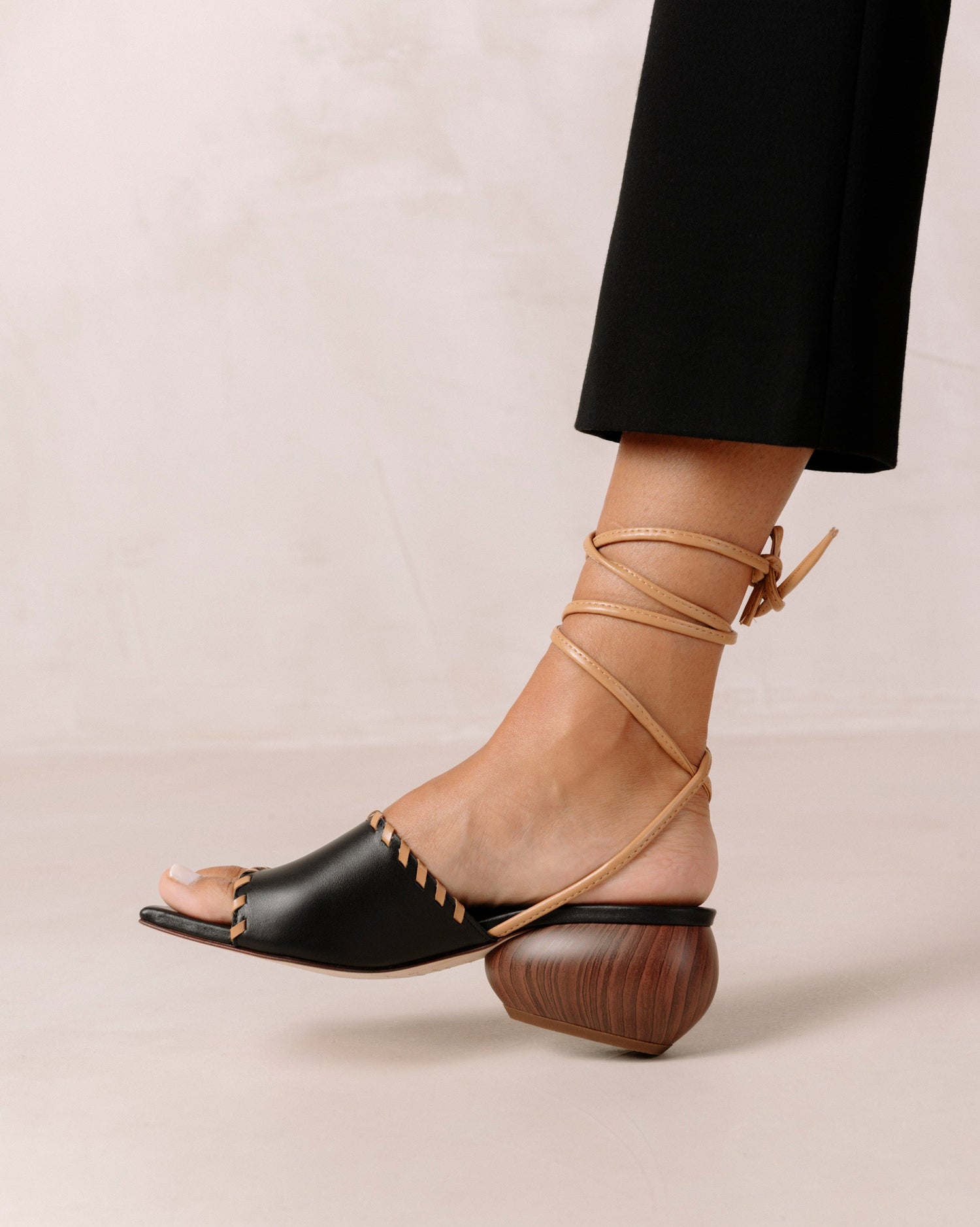 Thanks to their rounded mid heel and thick front strap, these chic lace-up sandals strike a balance between comfort and flair. Crafted from premium black leather, they have long, slim straps which wrap delicately around the ankle for a secure fit. Sustainably made in Spain. Alohas Kitty Black Leather Sandal.
