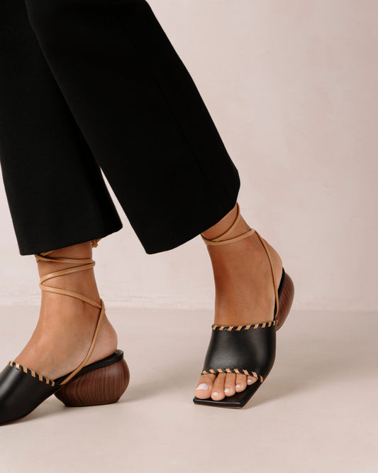 Thanks to their rounded mid heel and thick front strap, these chic lace-up sandals strike a balance between comfort and flair. Crafted from premium black leather, they have long, slim straps which wrap delicately around the ankle for a secure fit. Sustainably made in Spain. Alohas Kitty Black Leather Sandal.