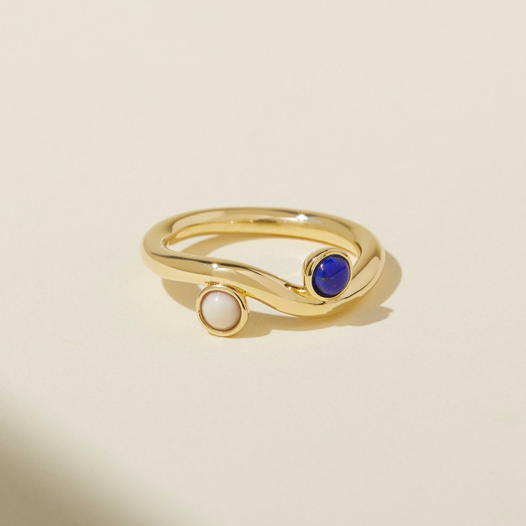 lindsay lewis wave ring sea palette - Cool tones are contrasted with warm golden yellow metal that curves like waves in a body of water. Lapis, the color of the ocean, and riverstone, the color of white sand, are why this combo is called the sea palette. Gold plated brass ring handmade by Lindsay Lewis.