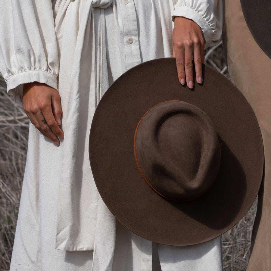 Minga's classic Rancher hat design, handmade from sheep's wool, is the perfect touch of sophistication. Wide-brimmed with a teardrop crown, and finished with a vegetable-tanned leather tie. Crafted with natural fibers makes for a versatile, all-season hat.