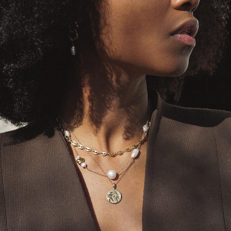 This satellite necklace includes varying sizes of baroque freshwater pearls and a gold accent heart. The perfectly imperfect pearls are connected with a 14k gold fill chain and hand-wrapped wire. All Dea Dia pieces are designed and handmade in Downtown Los Angeles.
