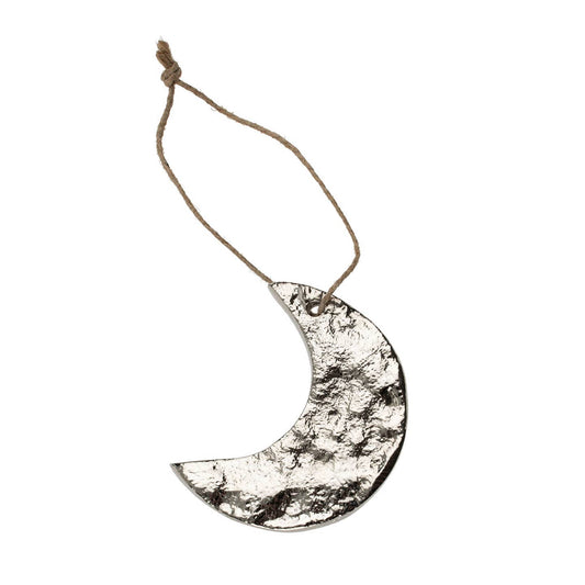 Decorative metal crescent moon hanging on a string against a white background