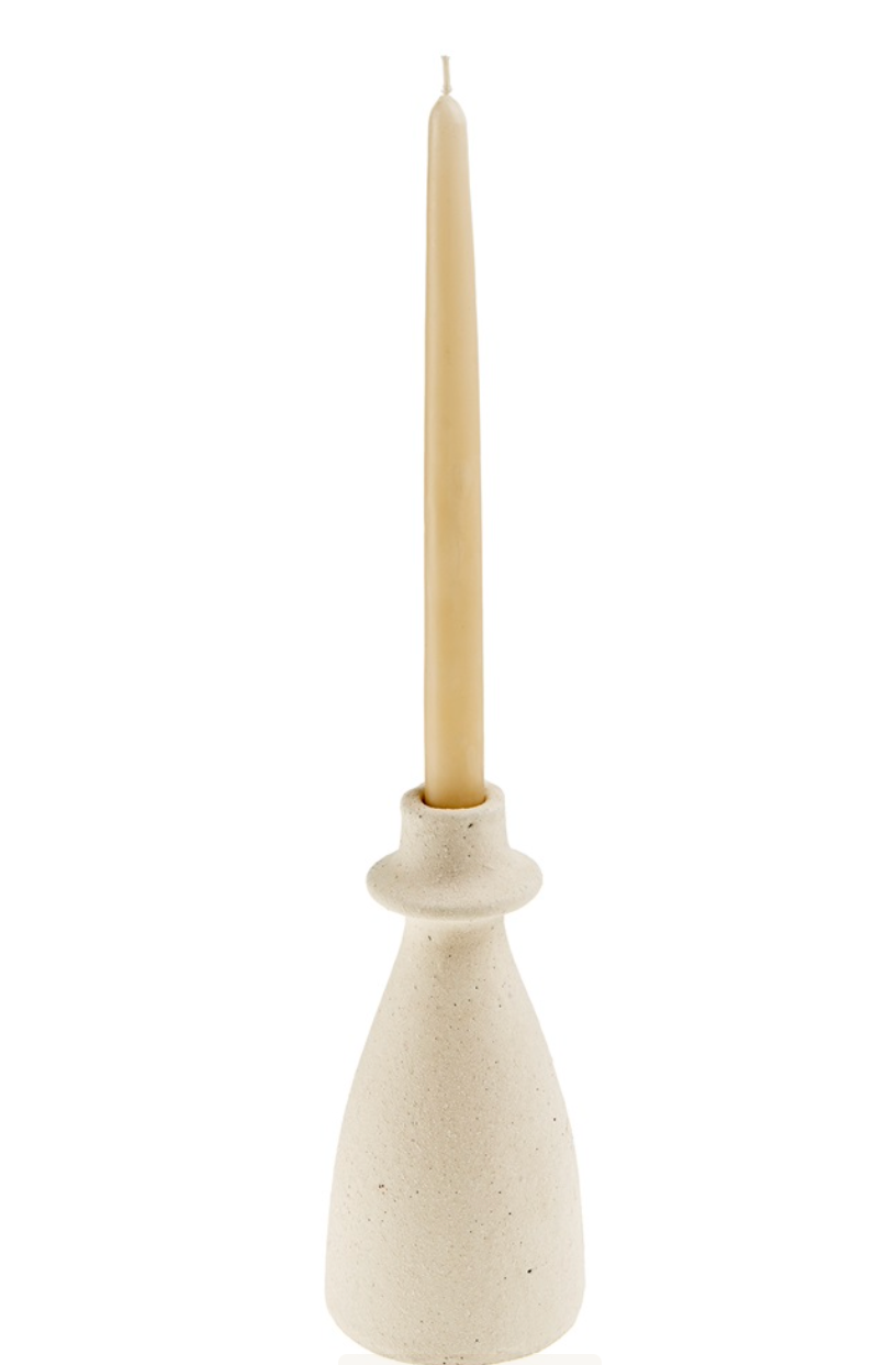 Ceramic candle holder with a beige candle on a white background