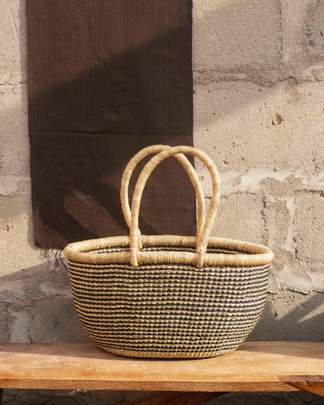 An oval-shaped basket, woven with black & white straw.  Perfect choice for a beach day, flower hunting adventure or for storing some of your favorite things. Also big enough to store blankets and toys. available at thread spun.