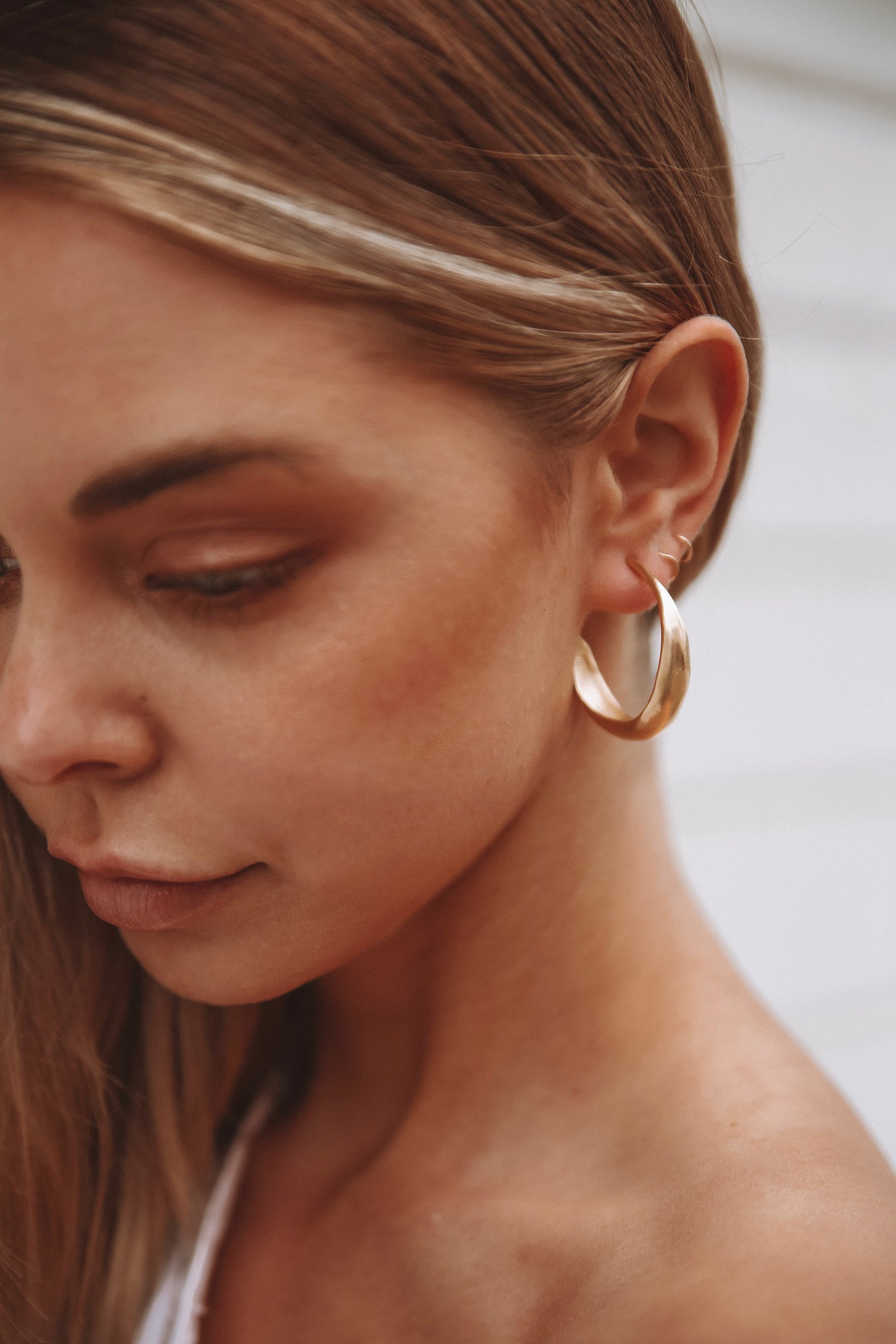 Textured organic simple light weight hoop earrings. This pair can be worn daily for a feminine, sculptural and elegant classic style. Earrings are made of recycled brass with sterling silver studs coated in a thick layer of high grade 14k gold. Handmade in the Santa Cruz Mountains.