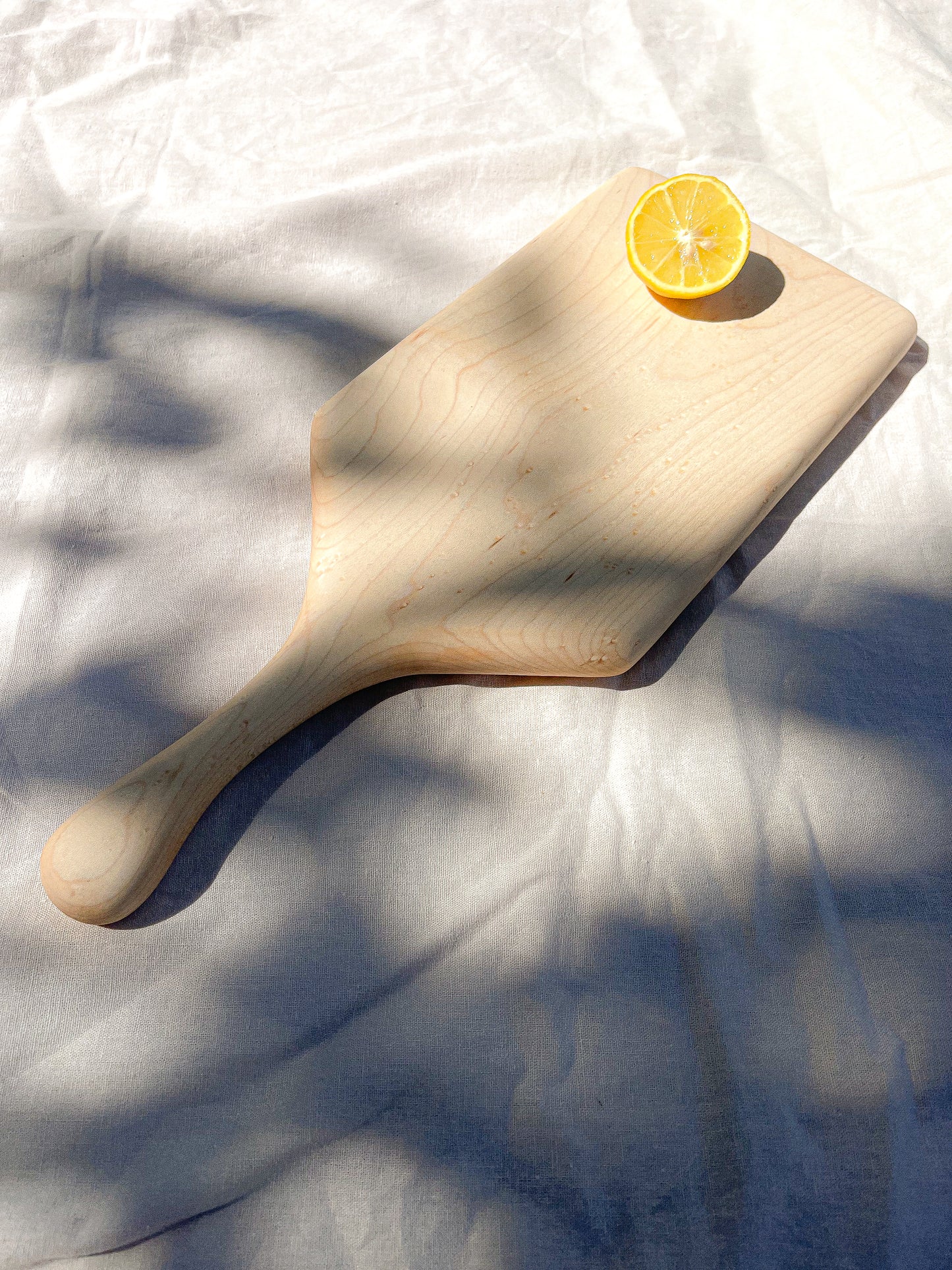 Hand-crafted cheeseboard perfect for a display of cheese or appetizers. The handle is perfect for carrying to the table, and adds visual interest. Made sustainably from maple wood in Gatineau, Canada.