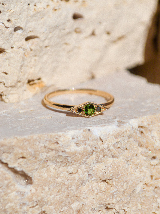 Deep blue green tourmaline encompassed in a diamond shape of solid 14k yellow gold and 2 black diamonds. A one of a kind ring inspired by an island in Scotland. Each Miarante piece is carefully handcrafted in Chicago by a skilled production team.