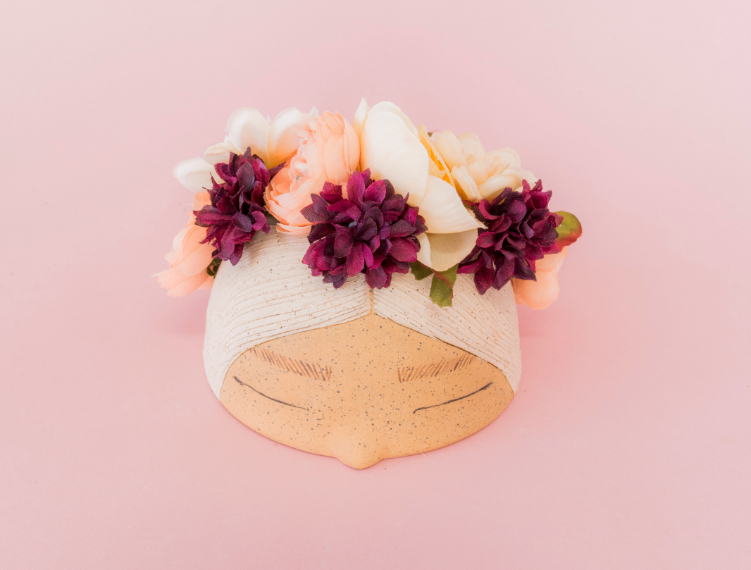 Ceramic, handmade flower crown is a ceramic woman's head with holes for dried or fresh flowers.