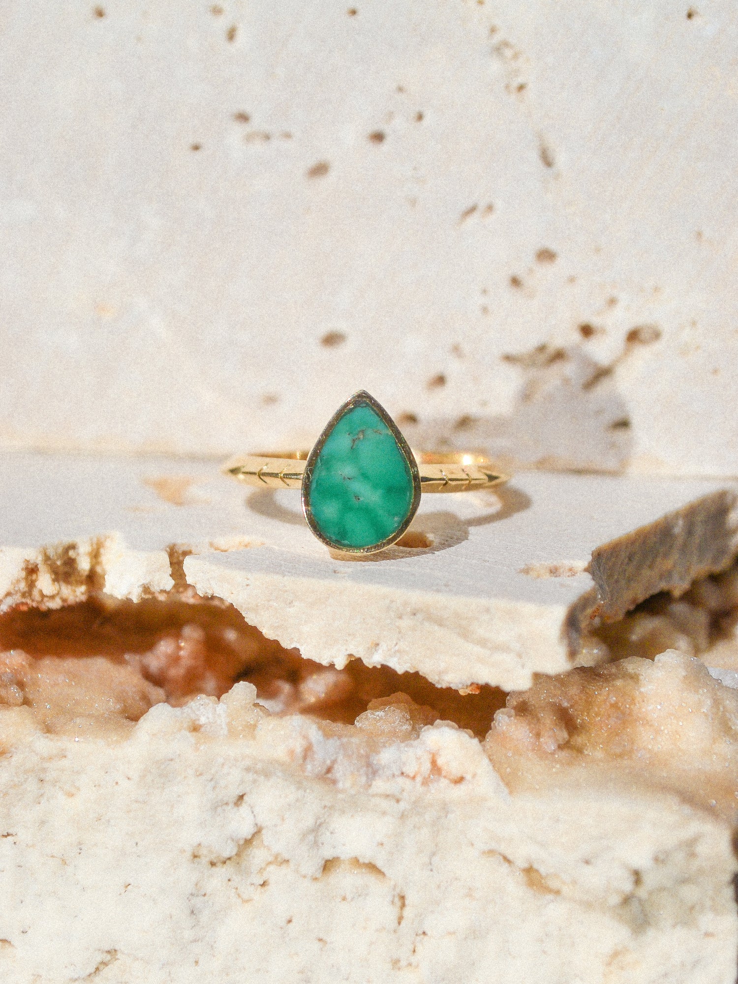 A teardrop of inlaid Broken Arrow Turquoise stone surrounded by 14k pure gold on a triangular hand carved signature Young in the Mountains Helena band