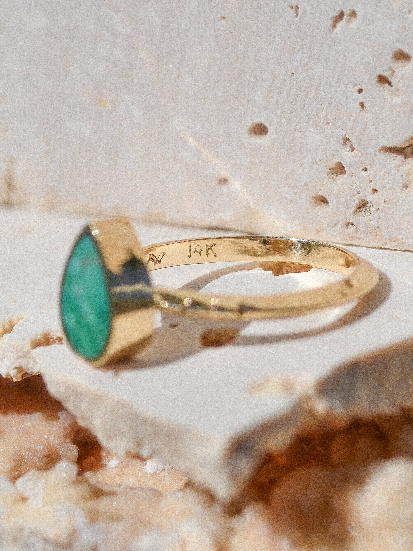A teardrop of inlaid Broken Arrow Turquoise stone surrounded by 14k pure gold on a triangular hand carved signature Young in the Mountains Helena band