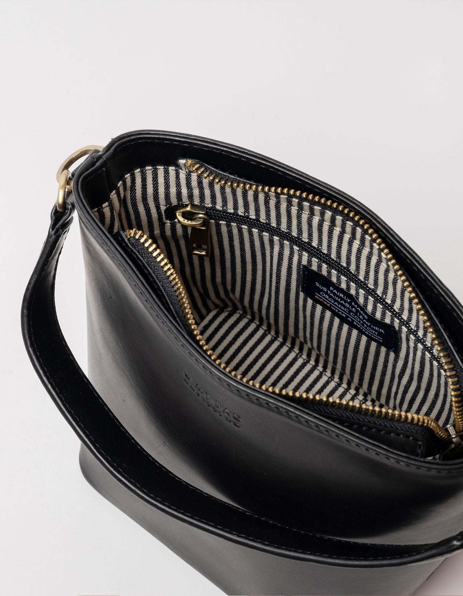 This classy bucket bag has one roomy interior and a slip-in pocket to grab your small essentials in a sec. Designed with a flat bottom, Bobbi stands on her own, making a true statement. Carry her with the top handle or wear her as a cross body bag. Made in India.