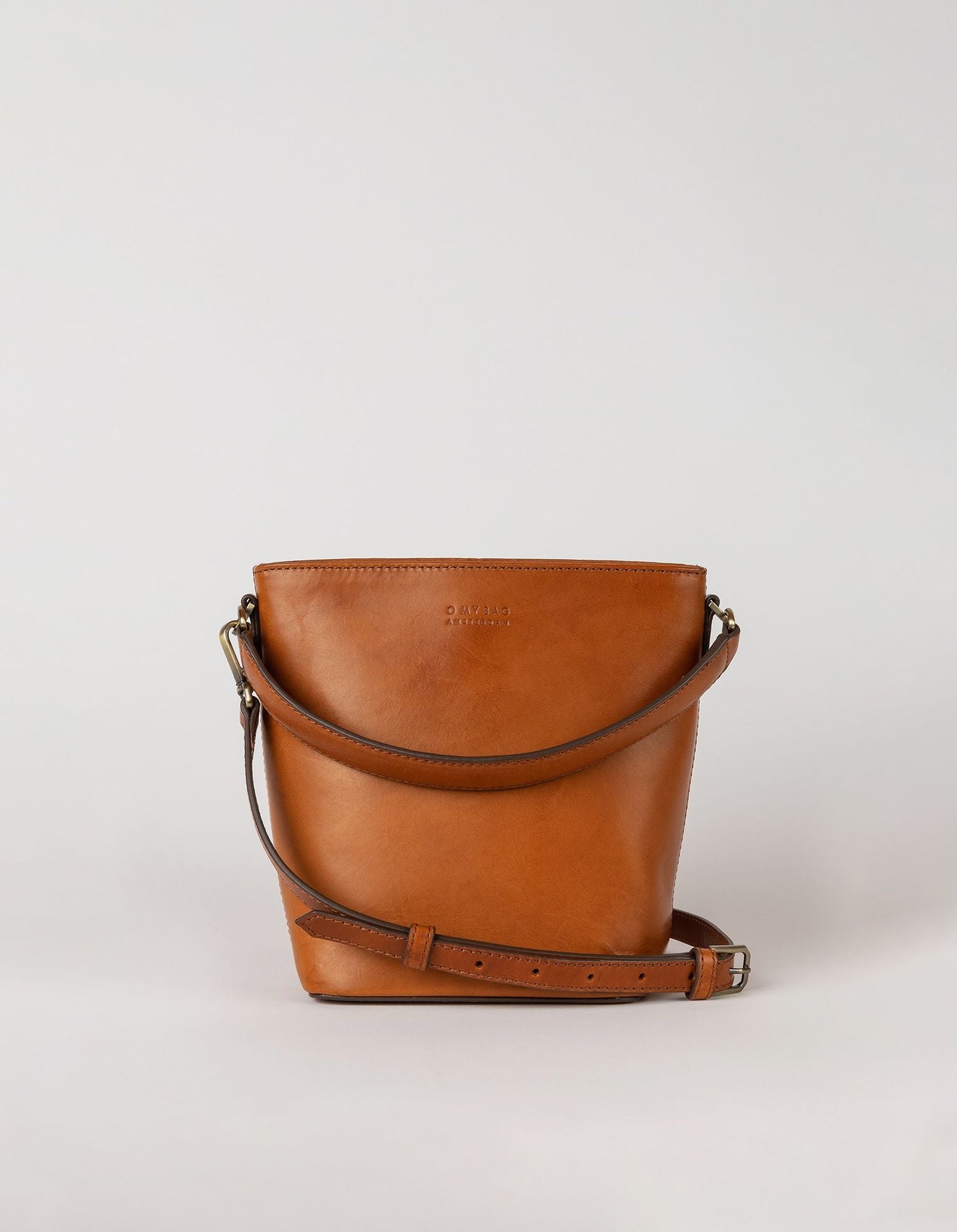This classy bucket bag has one roomy interior and a slip-in pocket to grab your small essentials in a sec. Designed with a flat bottom, Bobbi stands on her own, making a true statement. Carry her with the top handle or wear her as a cross body bag. Made in India.