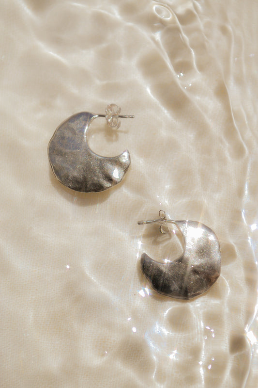 Bora Hoops by Amanda Hunt. A smooth yet slightly textured hoop. Light as a feather. Available in hand cast sterling silver with sterling silver posts or hand cast yellow bronze.
