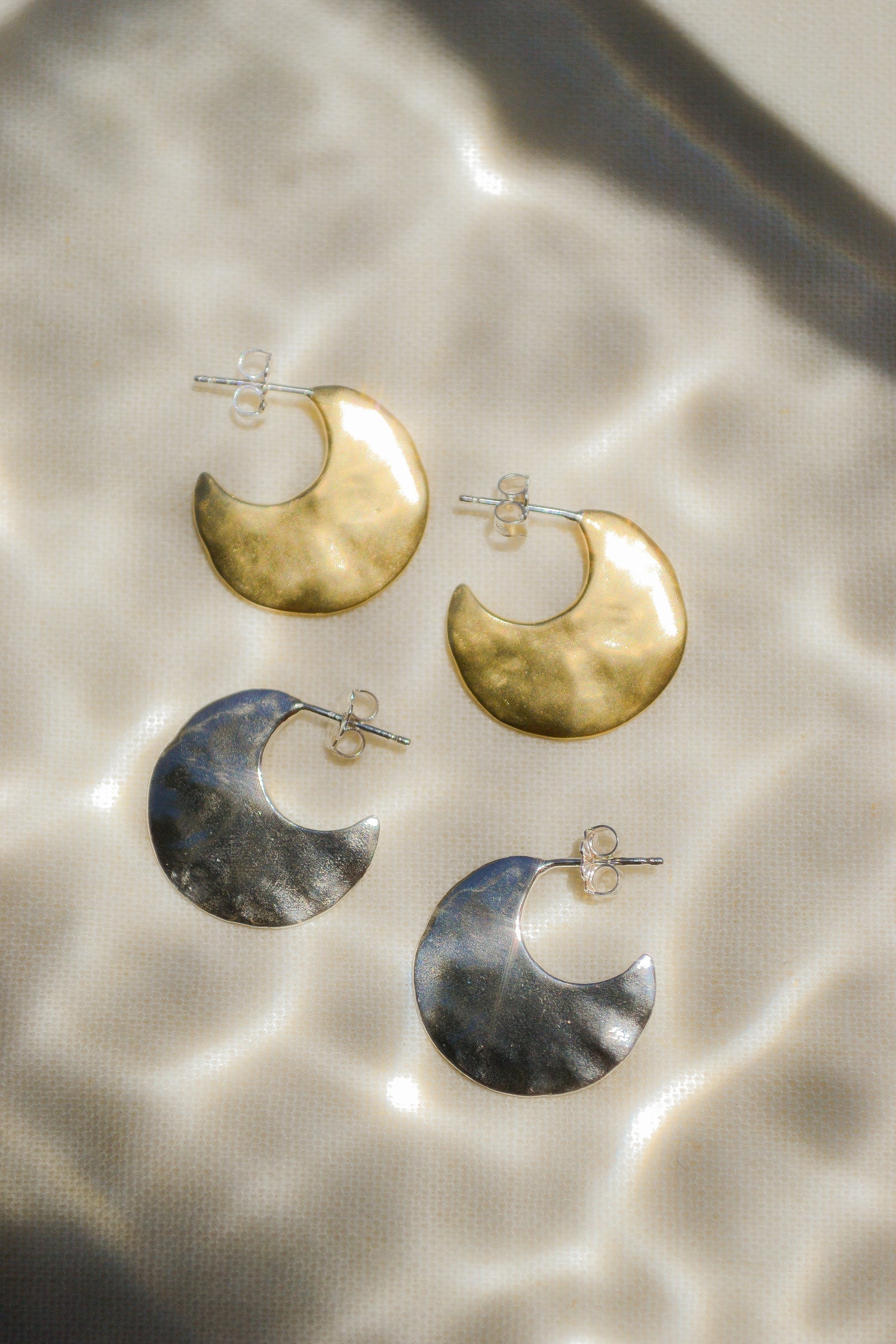Bora Hoops by Amanda Hunt. A smooth yet slightly textured hoop. Light as a feather. Available in hand cast sterling silver with sterling silver posts or hand cast yellow bronze.