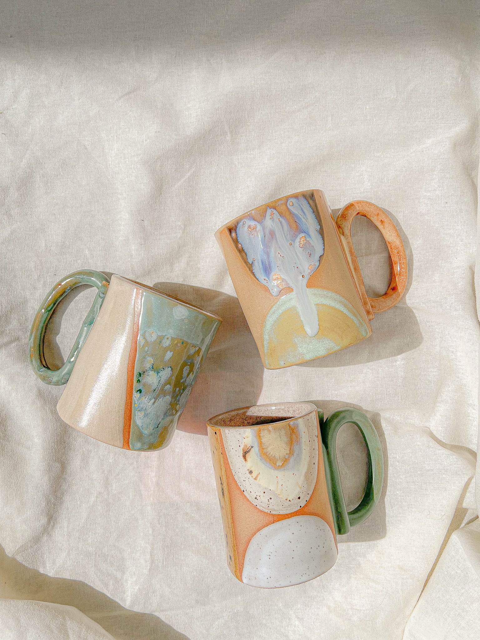 Handmade ceramic mug featuring unique glaze colors and a looped handle.