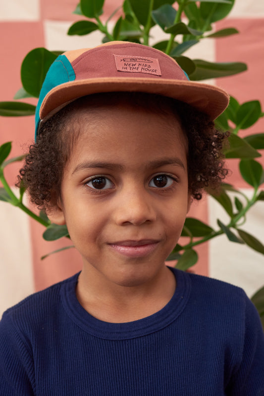 Calvin is a 5-panel cap for kids aged between 2 and 6. It is adjustable, so it grows with your kid. Made from pre-used bedlinen, with cotton lining & soft visor. The Atlantis model comes in rust, dark brown and teal shaded panels - Made in Germany