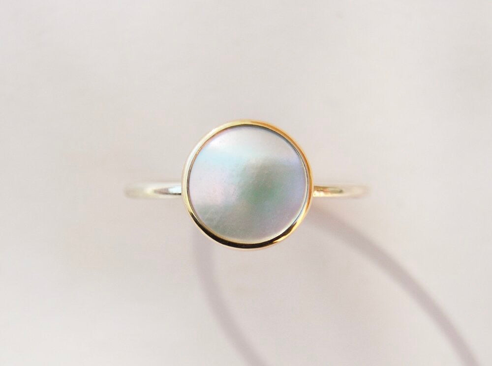 Made by hand in Northern New Mexico using recycled metals and responsibly sourced stones, this timeless, heirloom piece is sure to make a statement.  This ring features a white Mother of Pearl set in a 14k yellow Gold bezel on a Sterling Silver band.