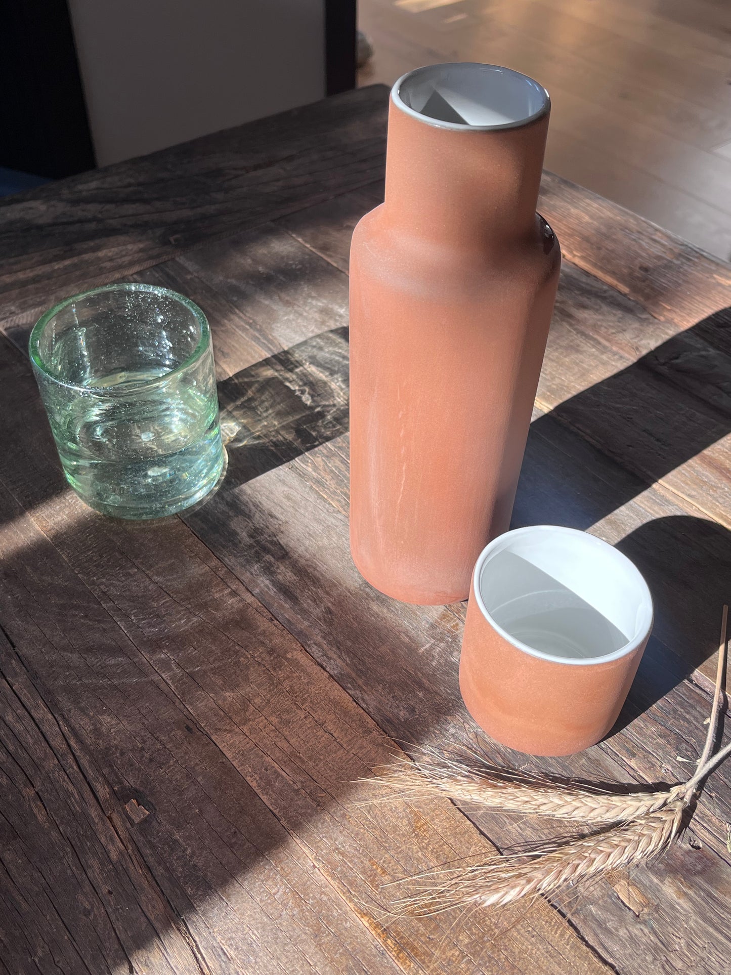 Stoneware; high-fire clay tableware carafe with ceramic cup. When not in use, handmade ceramic cup can be flipped over and fits as the carafe top. Handmade by artisans in Mexico.
