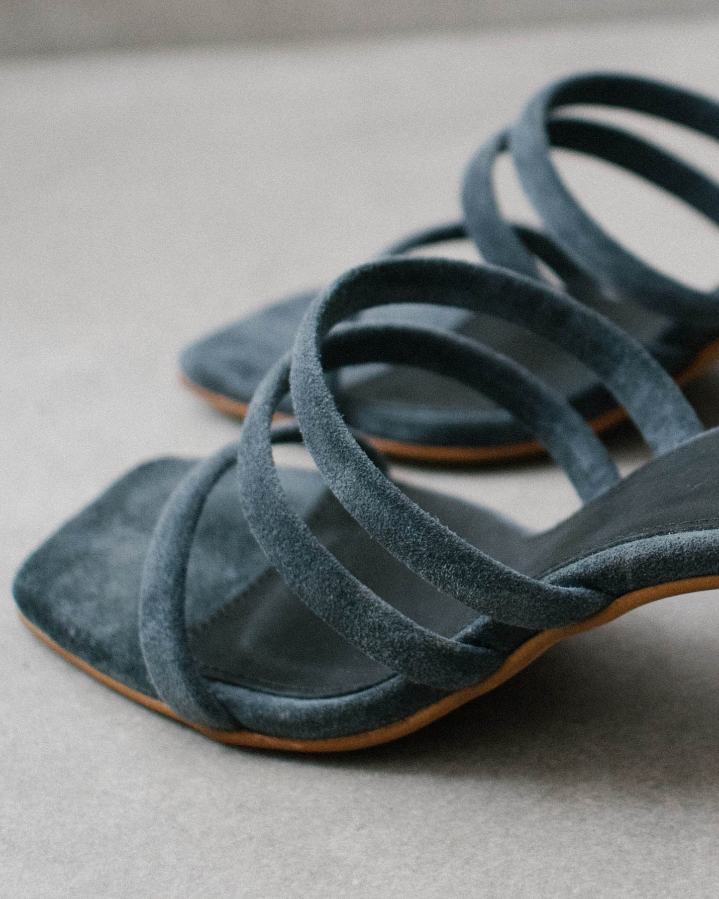 The Indiana Gray are the staple of the summer season. Defined by a minimalistic and timeless design, these suede sandals feature a curved block heel, one strap at the front and two parallel straps between the ankle and the instep, as well as a square toe for maximum flattery.