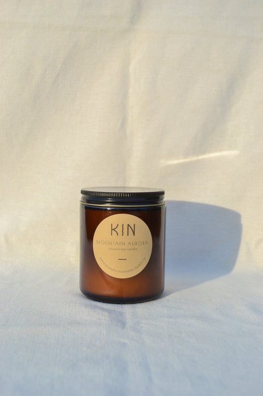 Mountain Aurora Candle by Kin Candle Co. Complex and alluring. This atmospheric blend of juniper and fir is inspired by the starry Sierra Mountain sky with scent notes of juniper, tobacco, and vanilla.