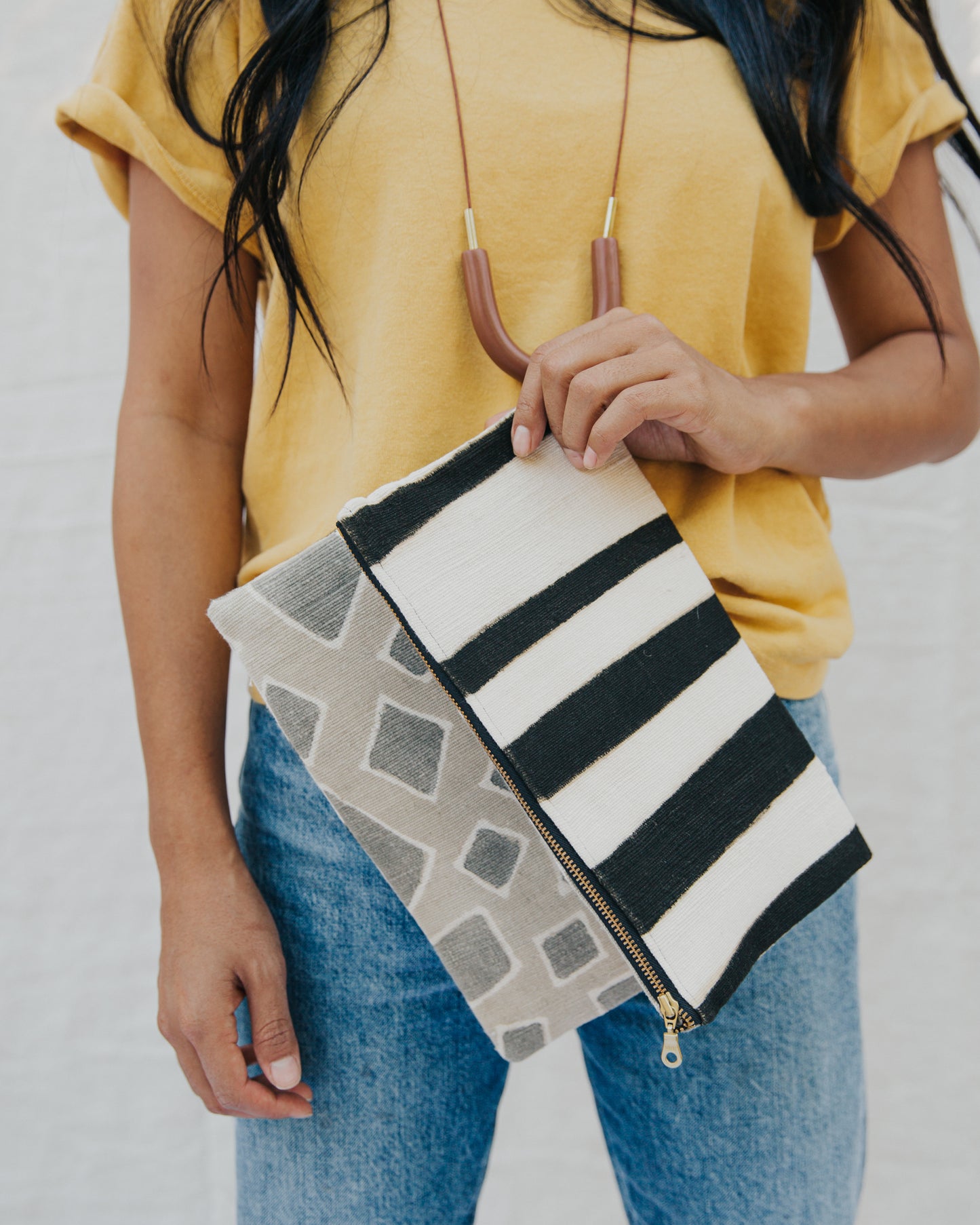 Handmade foldover/reversible clutch featuring fair trade textiles naturally-dyed by artisans from Mali. Each clutch is lined with 100% organic cotton. Sewn by our resettled refugee artisan, Lashta, locally in San Diego.