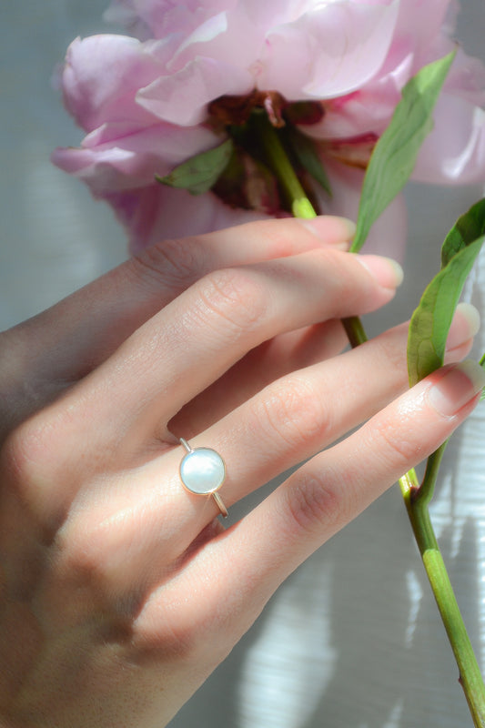 Made by hand in Northern New Mexico using recycled metals and responsibly sourced stones, this timeless, heirloom piece is sure to make a statement. This ring features a white Mother of Pearl set in a 14k yellow Gold bezel on a Sterling Silver band.