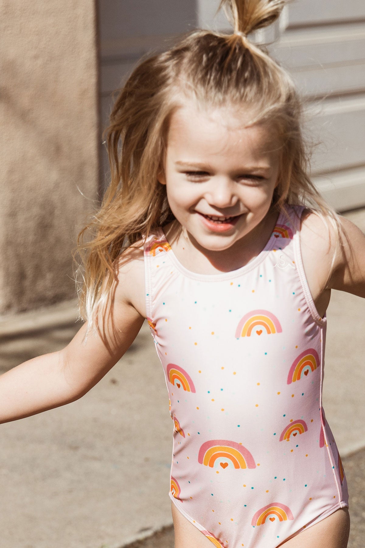 Custom rainbow print made exclusively for Seaesta Surf with a base color in a beautiful pastel pink. Seaesta Surf kids swimsuits are earth and performance conscious, featuring eco-friendly fabrics and a full coverage that stays in place while your little one plays.