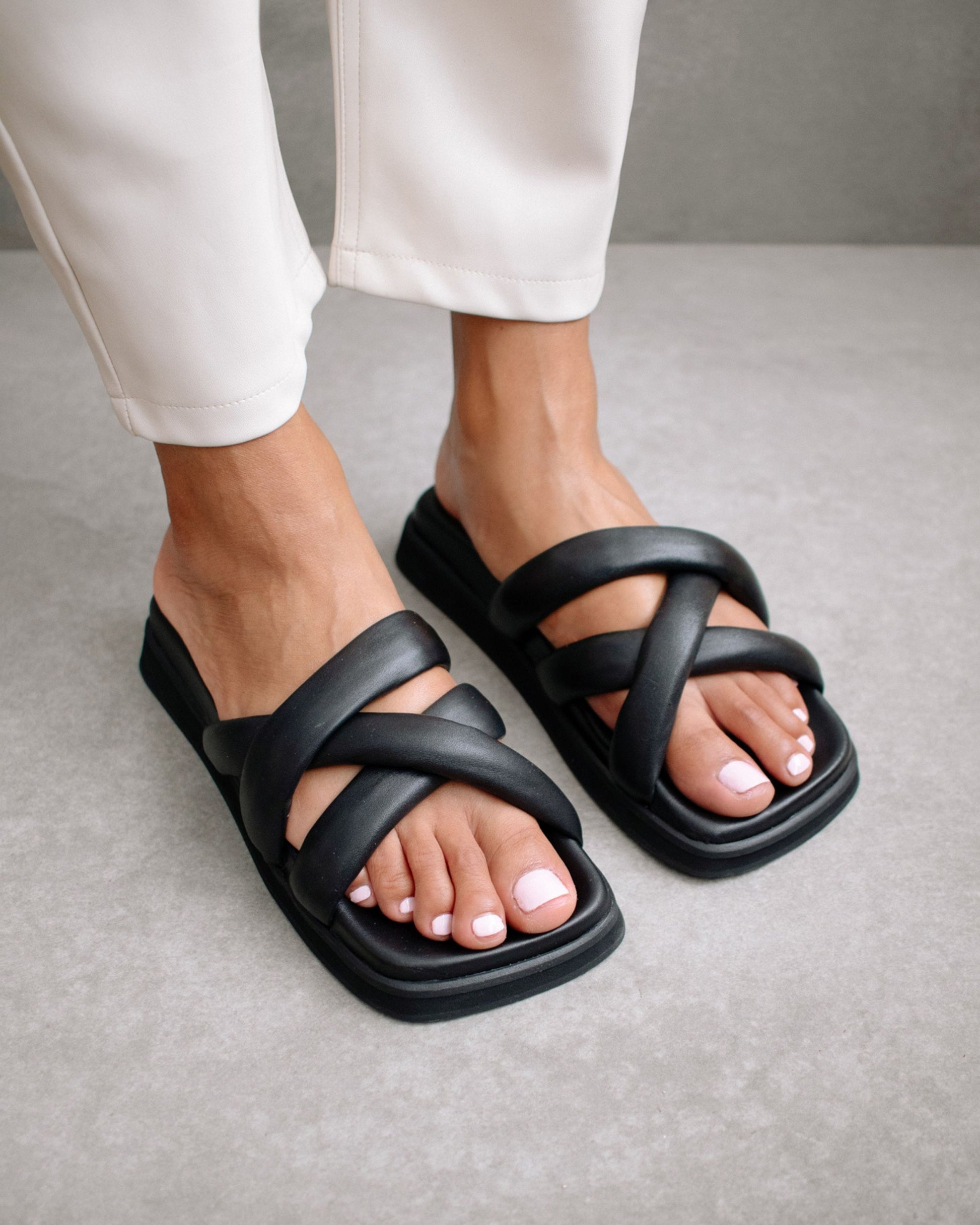 A polished, minimal design that stands the test of time. Made from supple black leather, featuring tubular criss-cross straps and cushioned stacked soles which make slipping into them a real treat for your feet. Sustainably made in Spain.