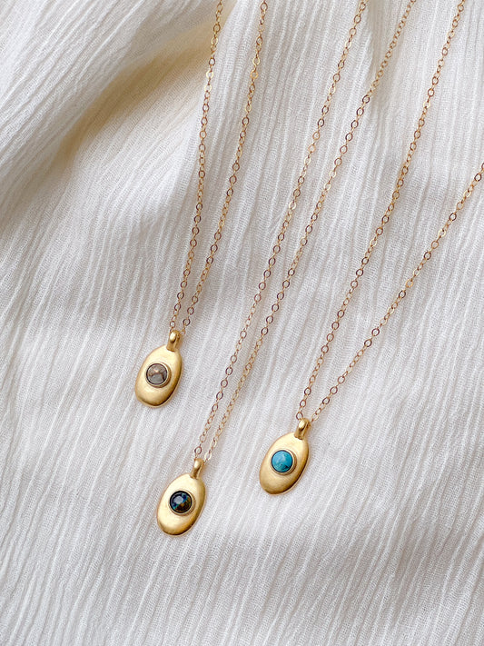 Sweet little handmade charm necklace featuring an ethically-mined turquoise, azurite, or copper calcite stone stone. Bronze with gold plating and a gold filled chain.